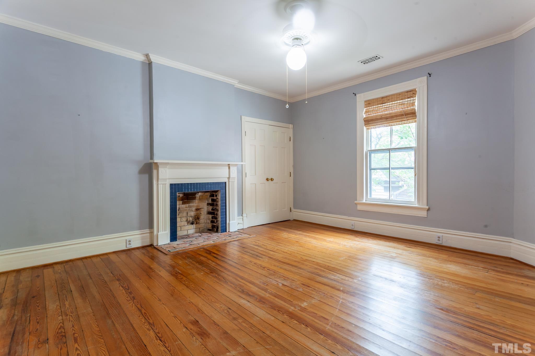 323 East Lane Street Raleigh, NC 27601 - Photo 30 of 42 an empty room with wooden floor fireplace and windows