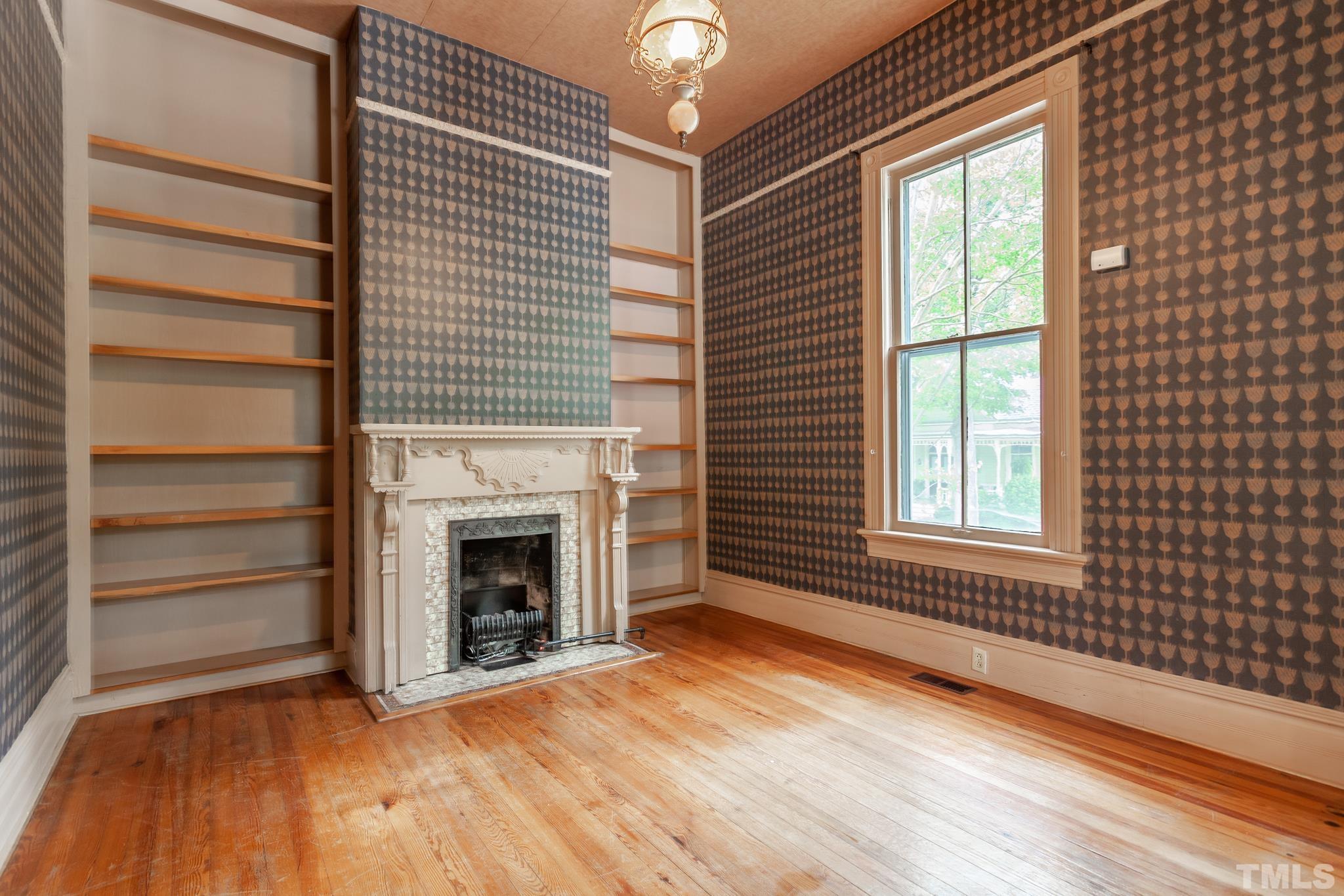 323 East Lane Street Raleigh, NC 27601 - Photo 10 of 42 a view of an empty room with a fireplace and a window
