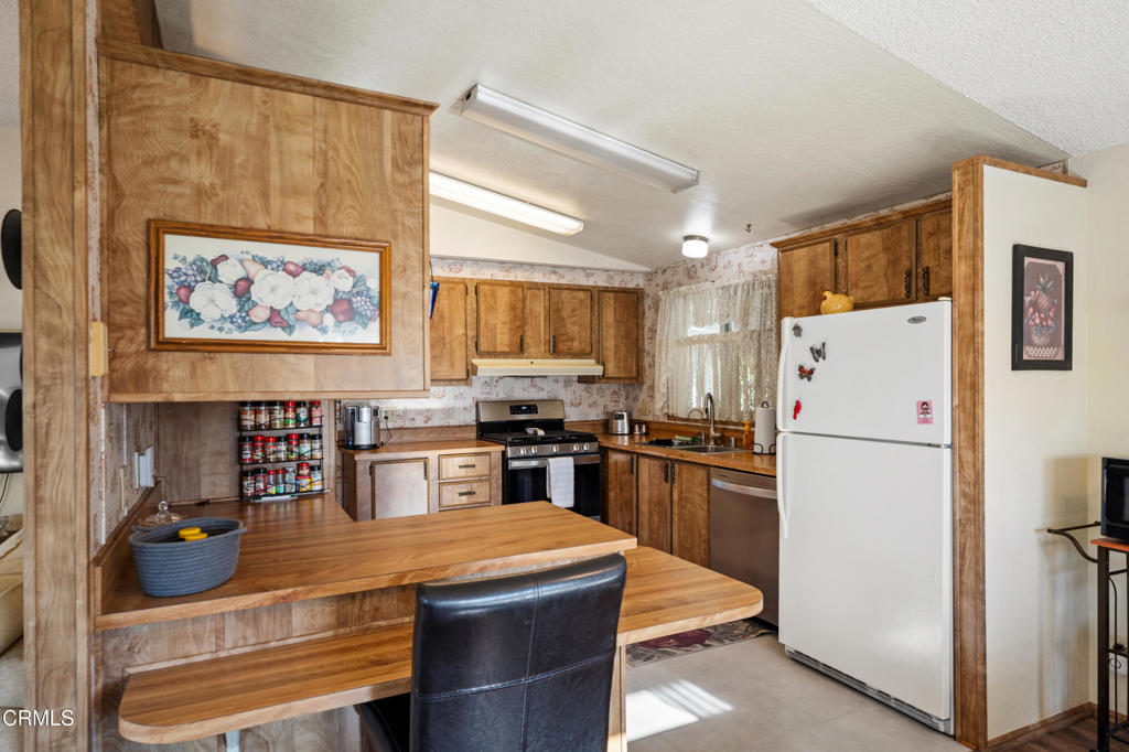 975 West Telegraph Road, Unit 10 Santa Paula, CA 93060 - Photo 7 of 21 a kitchen with stainless steel appliances granite countertop a refrigerator a stove a sink a microwave and with wooden cabinets