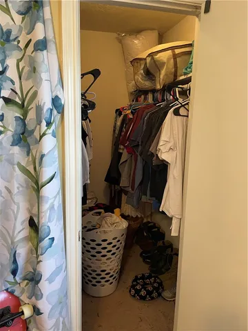 a view of walk in closet with clothes and shoes