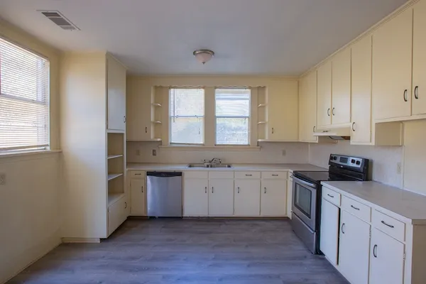 a view of a kitchen with wooden floor and windows in a room