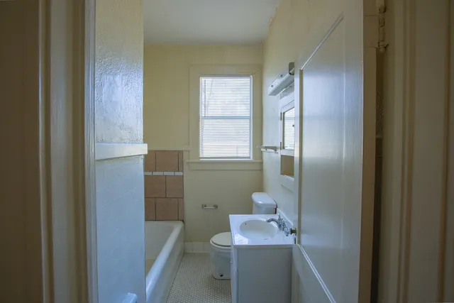 an empty room with windows and fireplace