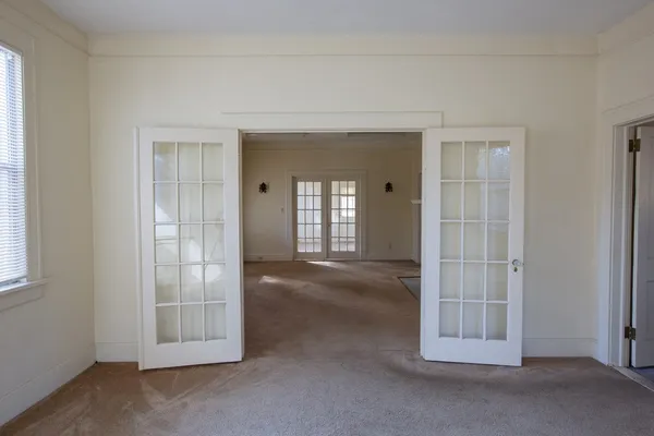 an empty room with windows and fireplace