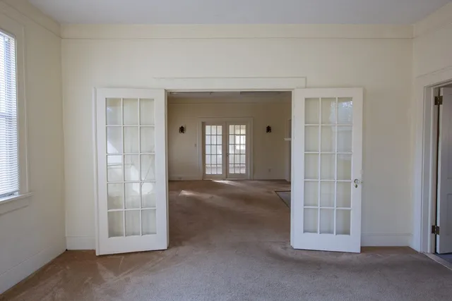 an empty room with windows and fireplace