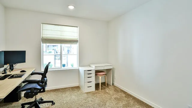 a view of a workspace with furniture and a window