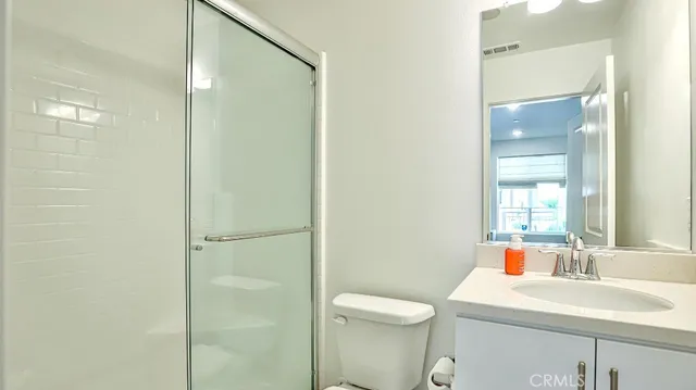 a bathroom with a sink toilet vanity and shower