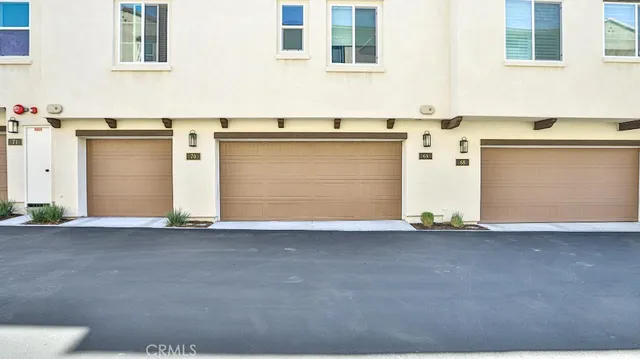a view of a white house with a yard and potted plants