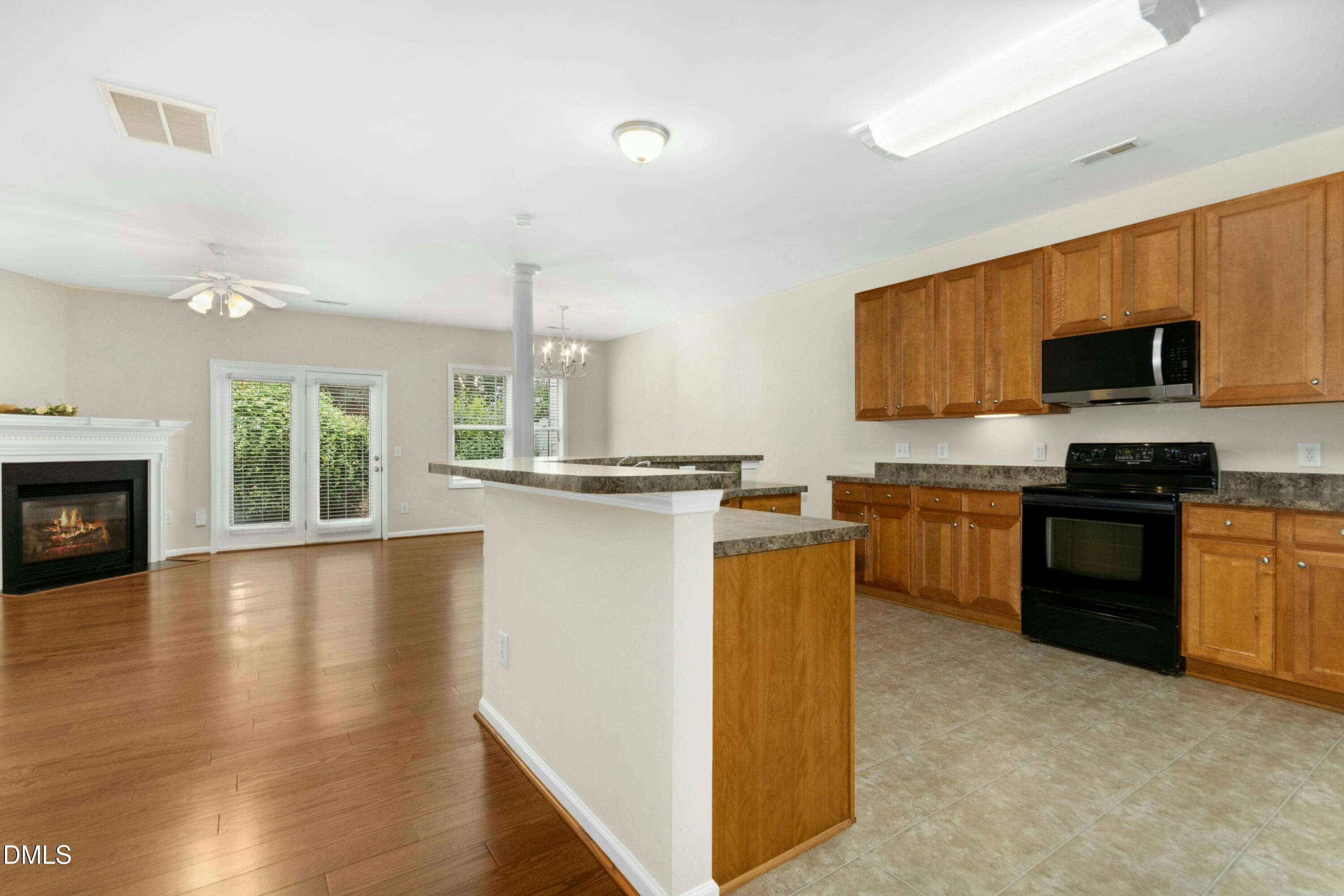 5541 Nur Lane Raleigh, NC 27606 - Photo 15 of 33 a kitchen with granite countertop a stove top oven a sink dishwasher a dining table and chairs with wooden floor