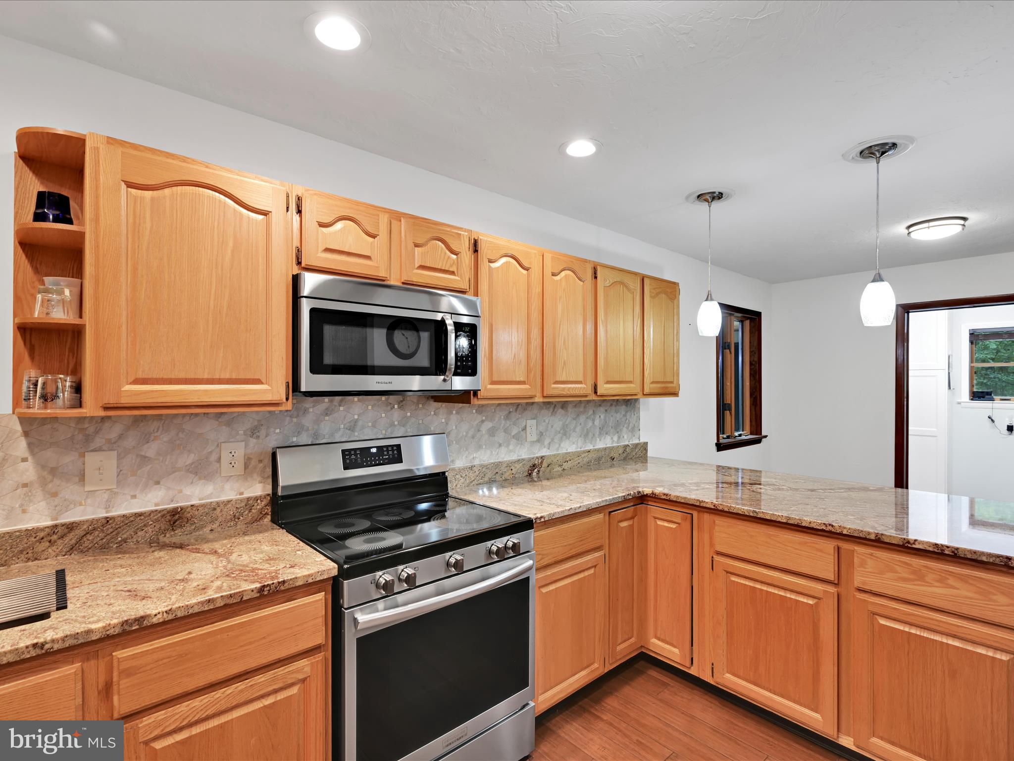 5150 Chestnut Grove Road Spring Grove, PA 17362 - Photo 13 of 56 a kitchen with stainless steel appliances granite countertop a stove a sink and a microwave