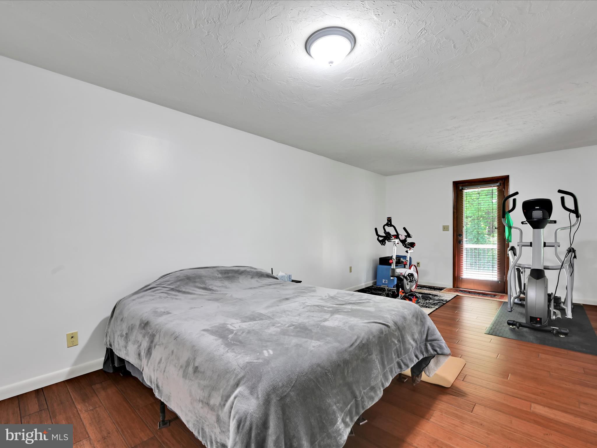 5150 Chestnut Grove Road Spring Grove, PA 17362 - Photo 30 of 56 a bed sitting in a spacious bedroom next to a window and wooden floor