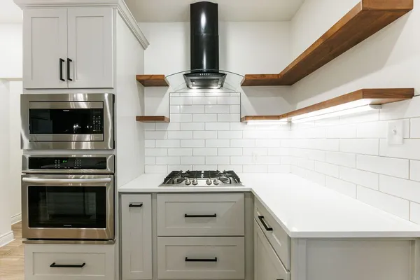 a kitchen with a stove and white cabinets