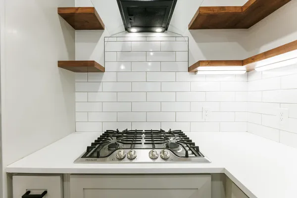 a kitchen with a stove and a white cabinet