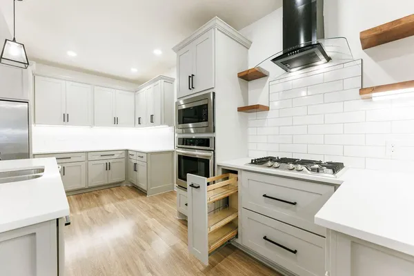 a kitchen with granite countertop a stove oven and white cabinets