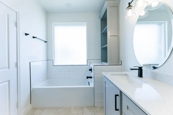a bathroom with a tub sink and mirror