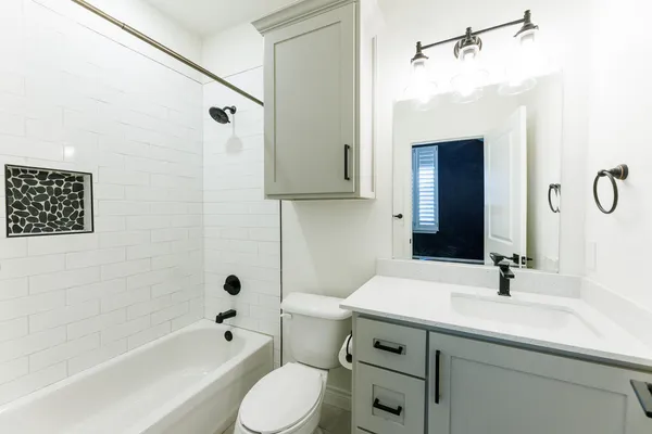 a bathroom with a sink a toilet and shower