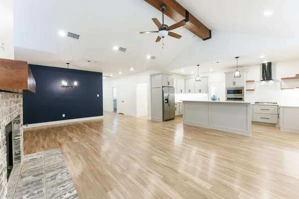 a view of a kitchen with kitchen island a sink stainless steel appliances and cabinets