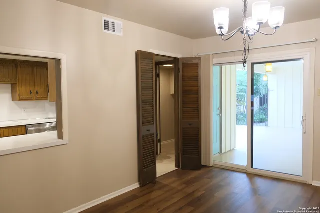 a view of a room with wooden floor chandelier and closet