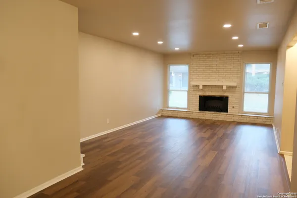 an empty room with wooden floor and fireplace