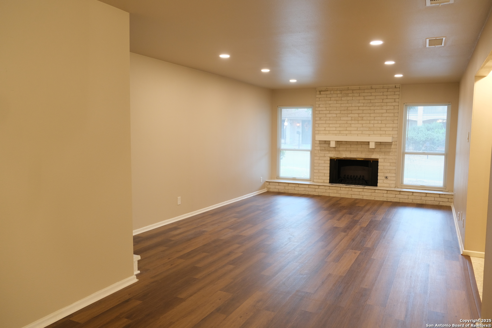 393 Fenwick Drive Windcrest, TX 78239 - Photo 16 of 42 an empty room with wooden floor and fireplace