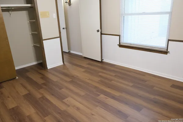 an empty room with wooden floor and a window