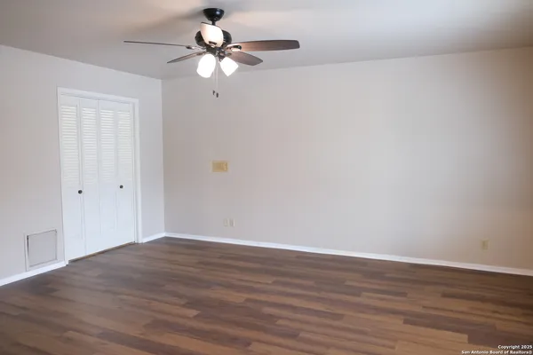 a view of an empty room with wooden floor