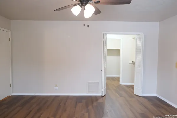 an empty room with wooden floor and mirror