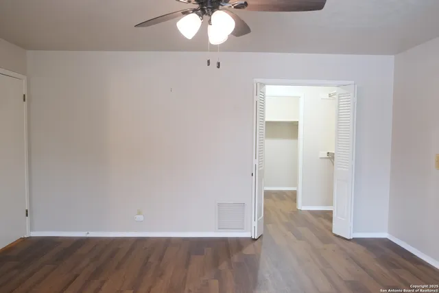 an empty room with wooden floor and mirror
