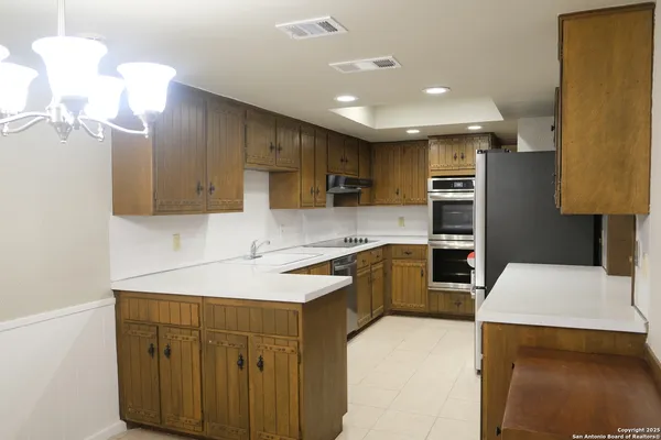 a kitchen with kitchen island a sink stainless steel appliances and cabinets