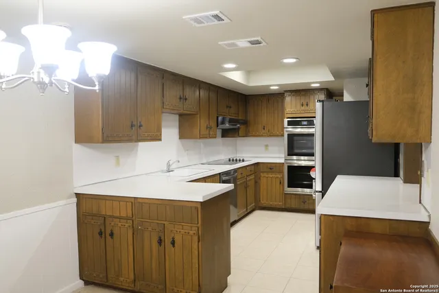 a kitchen with kitchen island a sink stainless steel appliances and cabinets