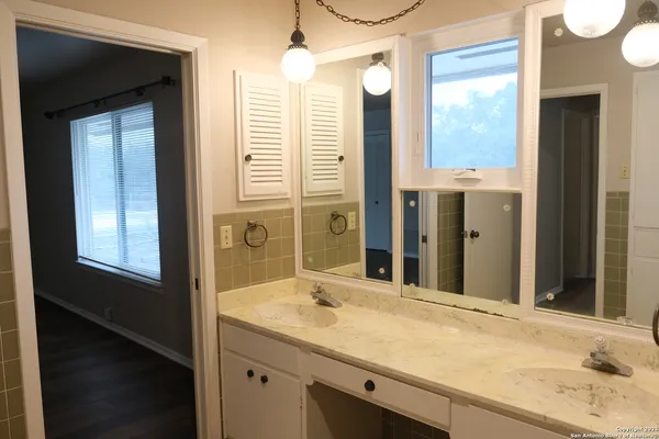 a bathroom with a granite countertop sink and a mirror