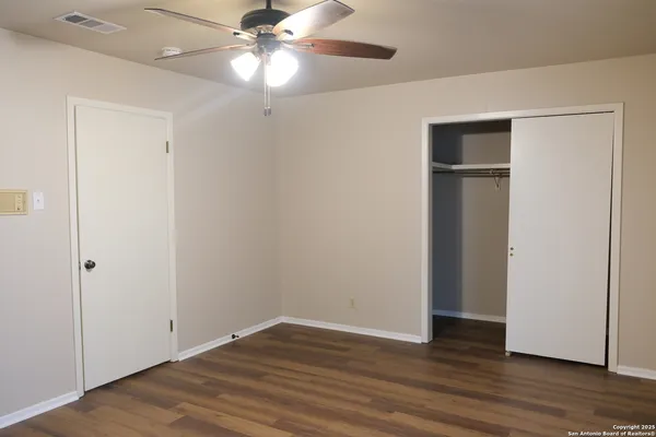 a view of an empty room with wooden floor