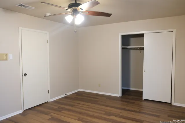 a view of an empty room with wooden floor