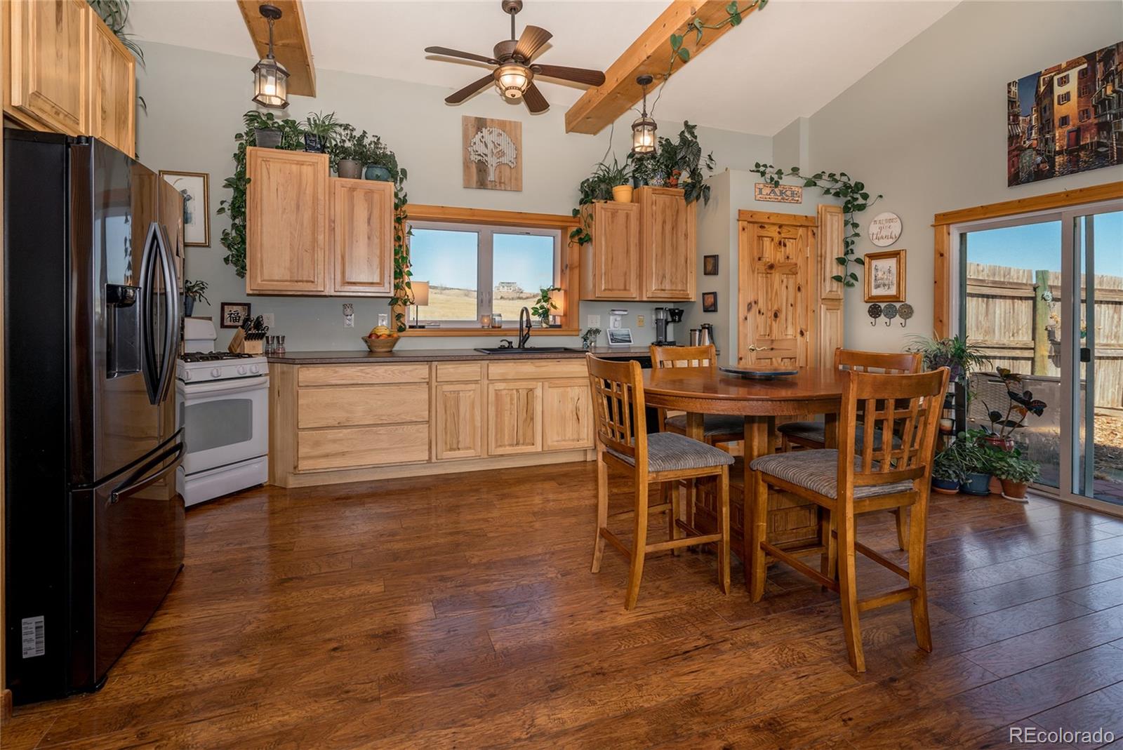 10320 Miners Lake Road Fort Collins, CO 80524 - Photo 5 of 39 a kitchen with stainless steel appliances kitchen island granite countertop a table chairs sink and cabinets