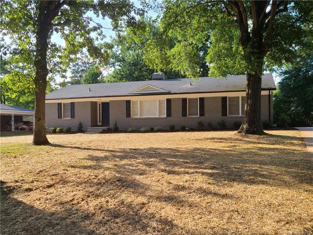 a front view of house with yard and trees around