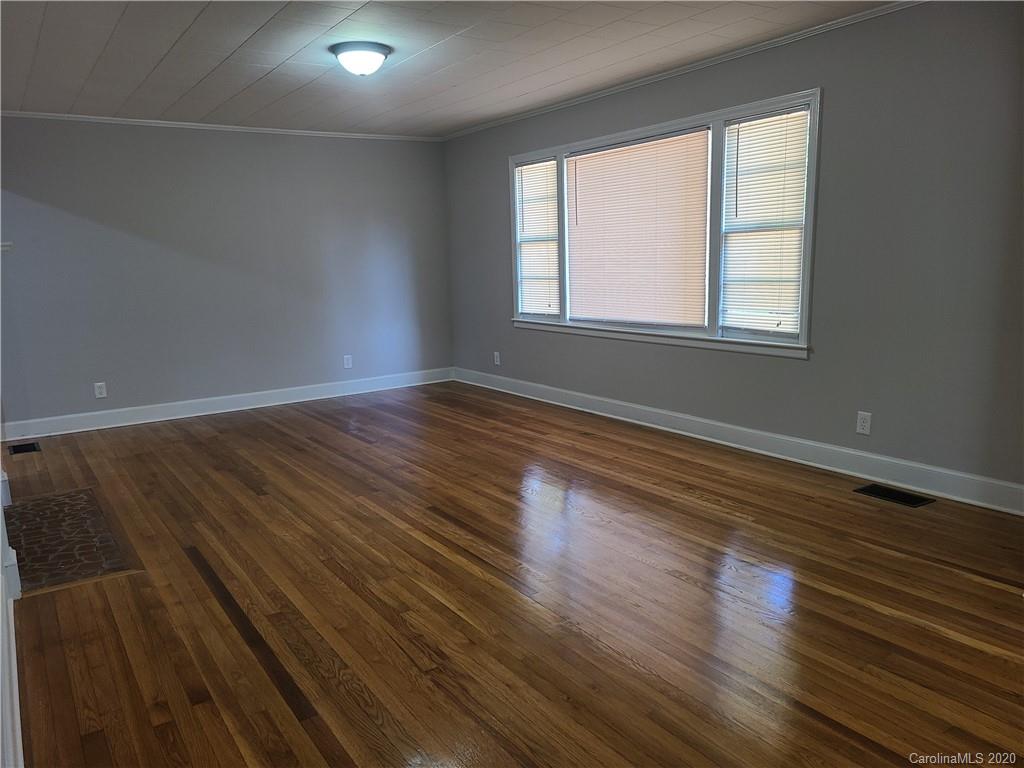 1820 Linwood Road Gastonia, NC 28052 - Photo 12 of 24 a view of an empty room with wooden floor and a window