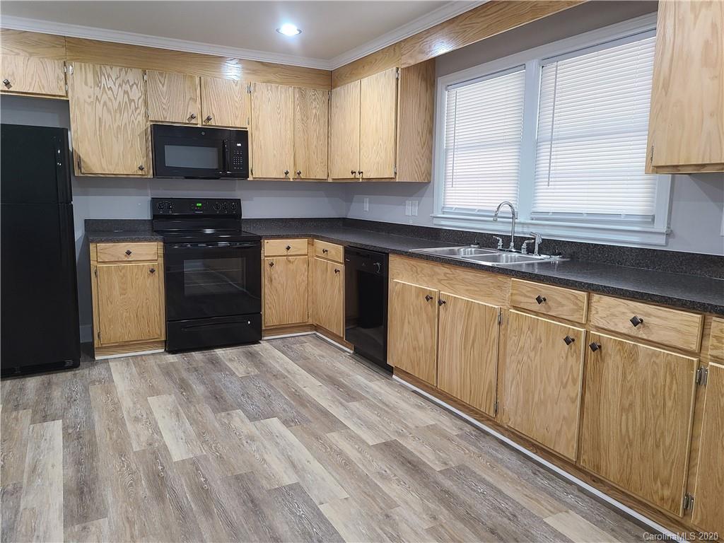 1820 Linwood Road Gastonia, NC 28052 - Photo 5 of 24 a kitchen with granite countertop a stove a sink and a microwave