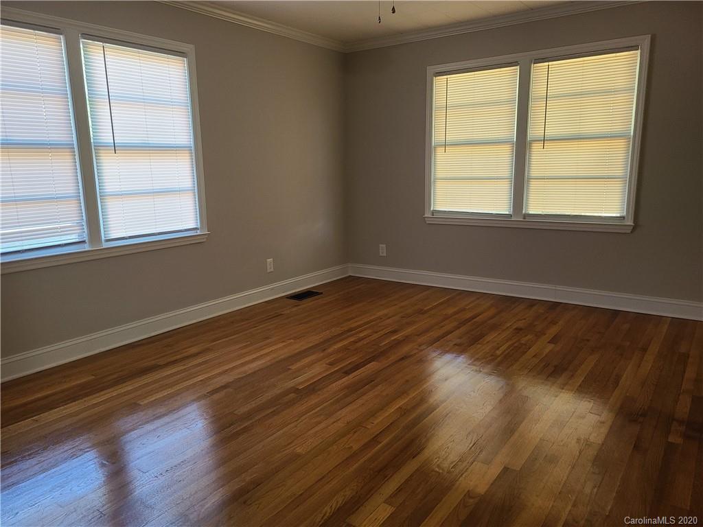 1820 Linwood Road Gastonia, NC 28052 - Photo 7 of 24 an empty room with wooden floor and windows