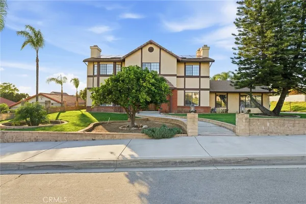 a front view of a house with a yard and potted plants