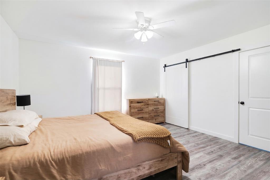 600 Private Road Brookston, TX 75421 - Photo 13 of 26 a bedroom with a white bed and a chandelier