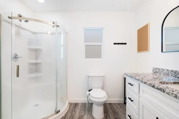 a bathroom with a granite countertop sink toilet and shower