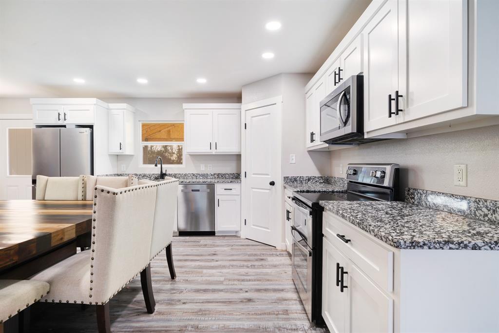 600 Private Road Brookston, TX 75421 - Photo 8 of 26 a kitchen with stainless steel appliances granite countertop a white cabinets and wooden floor