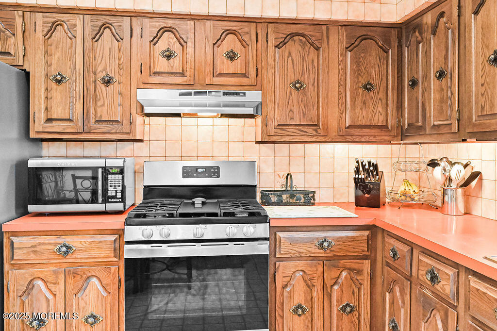 308 Stone Road Hazlet, NJ 07730 - Photo 37 of 58 a kitchen with granite countertop a stove sink and cabinets