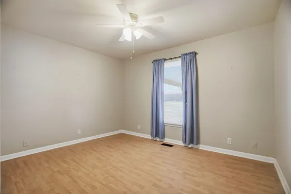 an empty room with a chandelier fan