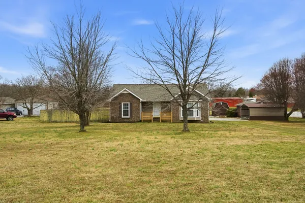 a front view of a house with a yard and trees