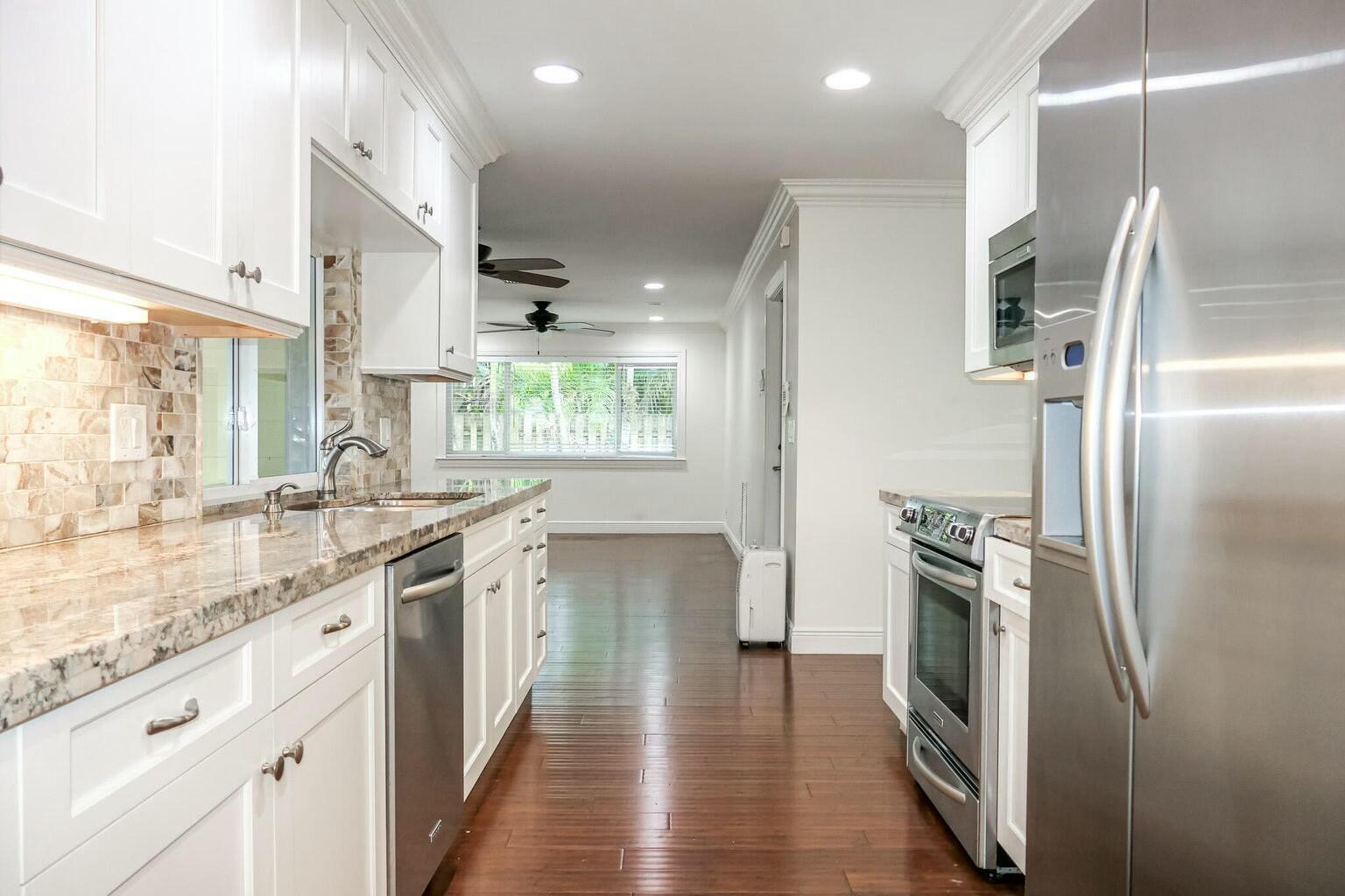 18014 Perigon Way Jupiter, FL 33458 - Photo 11 of 35 a kitchen with stainless steel appliances granite countertop a refrigerator and a sink