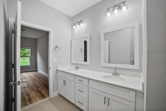 a en suite bathroom with a double vanity sink and a mirror