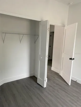 an empty room with wooden floor and a window