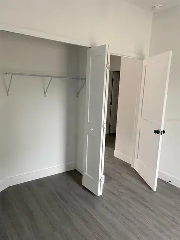 an empty room with wooden floor and a window