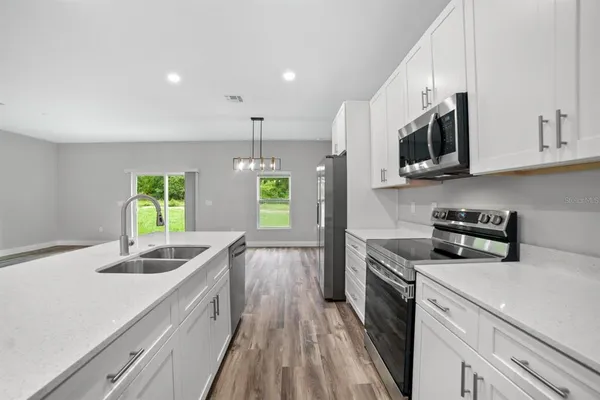 a kitchen with stainless steel appliances granite countertop a sink stove and microwave