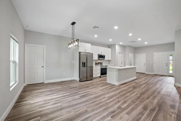 a view of kitchen with granite countertop cabinets and refrigerator